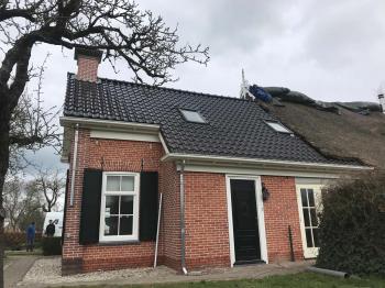 In Kortrijk nieuwe koramic vhv zwart verglaasde dakpannen gelegd.