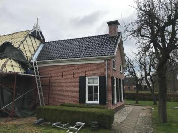 In Kortrijk nieuwe koramic vhv zwart verglaasde dakpannen gelegd.